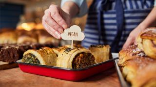 Image of vegan baked goods in a tray with a Vegan label topper